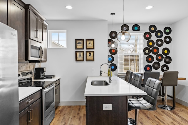 kitchen featuring appliances with stainless steel finishes, a breakfast bar, sink, and a wealth of natural light