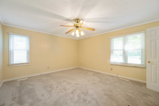 unfurnished room with ceiling fan, a healthy amount of sunlight, crown molding, and light colored carpet