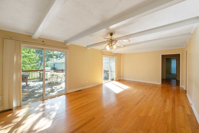 spare room with light hardwood / wood-style floors, a textured ceiling, beam ceiling, and ceiling fan