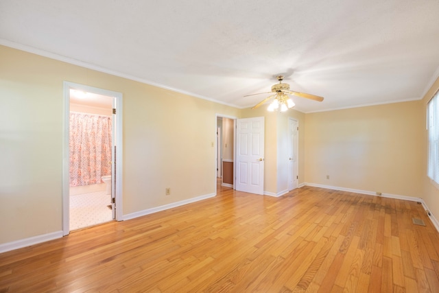 empty room with ceiling fan, ornamental molding, and light wood-type flooring