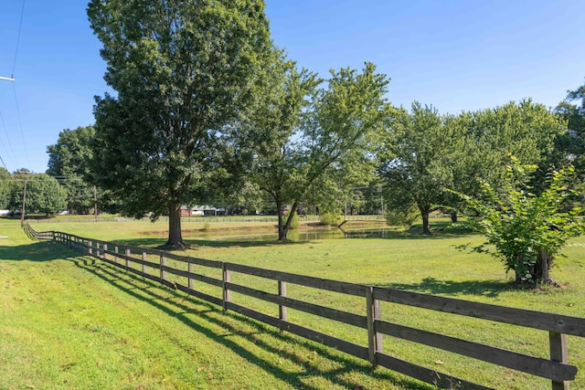 view of gate with a rural view and a yard