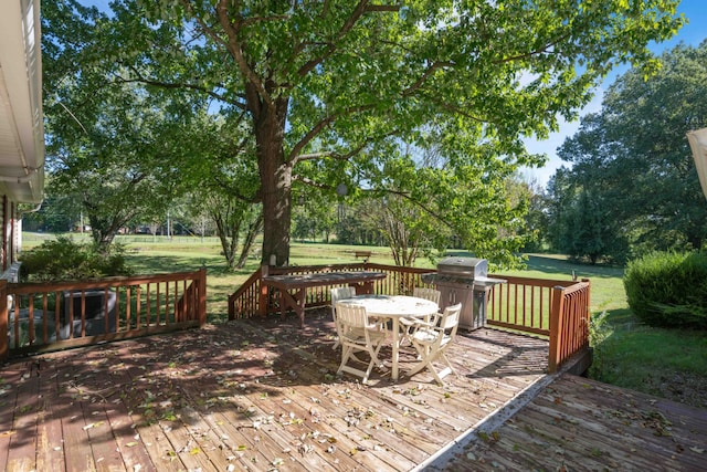 wooden deck featuring area for grilling and a lawn