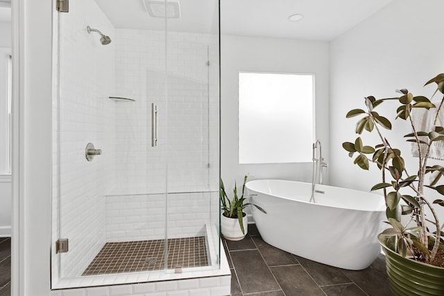 bathroom with tile patterned flooring and shower with separate bathtub