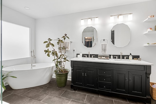 bathroom featuring tile patterned flooring, vanity, and a tub