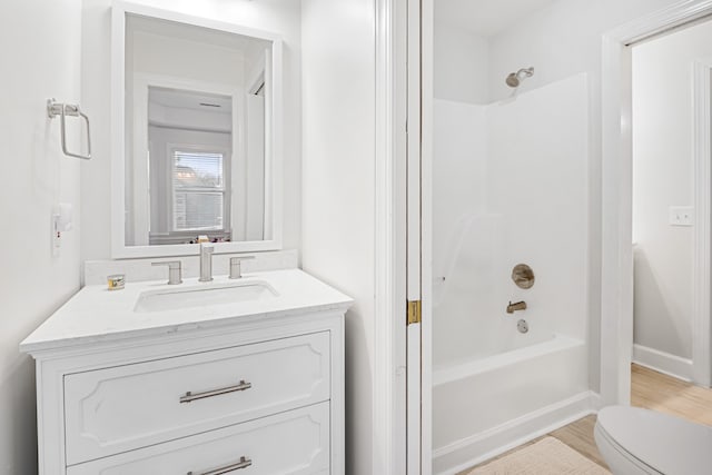 full bathroom featuring vanity, hardwood / wood-style flooring, toilet, and bathtub / shower combination