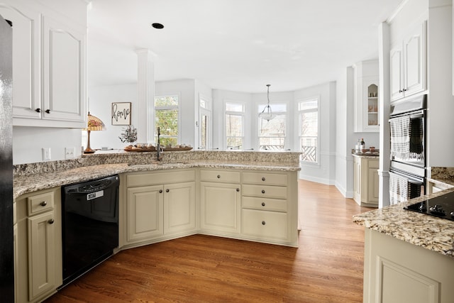 kitchen with sink, black appliances, light stone counters, and light hardwood / wood-style flooring