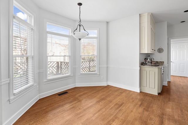 unfurnished dining area featuring a wealth of natural light and light wood-type flooring