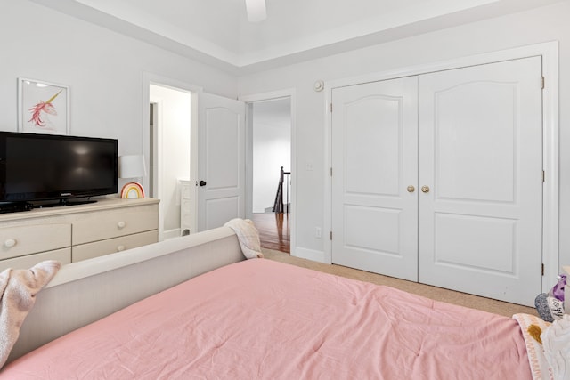 carpeted bedroom with ceiling fan and a closet