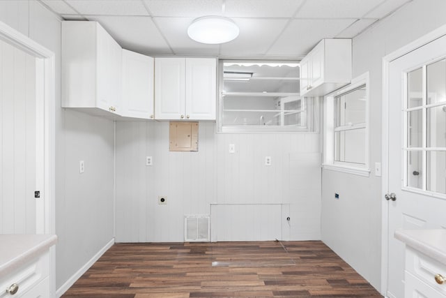 washroom featuring hookup for an electric dryer, dark hardwood / wood-style floors, electric panel, and wooden walls