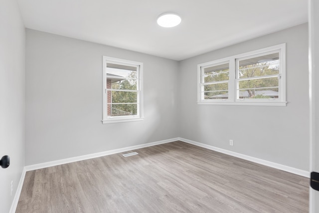 spare room featuring light hardwood / wood-style floors and a wealth of natural light