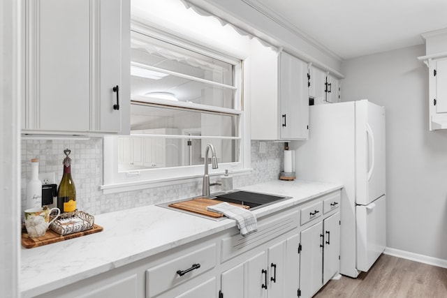 kitchen featuring light stone counters, decorative backsplash, light hardwood / wood-style flooring, and white cabinets