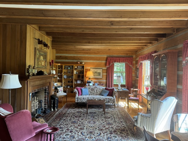 living room with beamed ceiling, wood walls, and hardwood / wood-style flooring