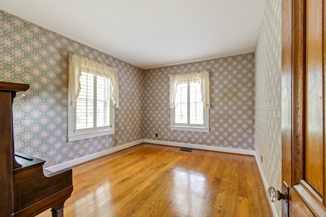 empty room with hardwood / wood-style floors and a wealth of natural light