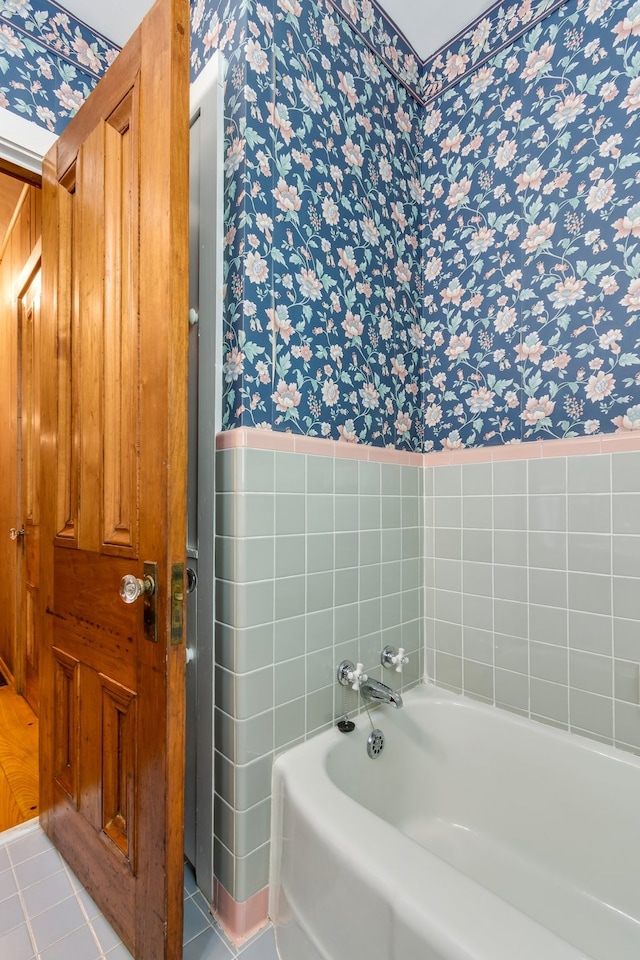 bathroom with tile patterned floors and a tub