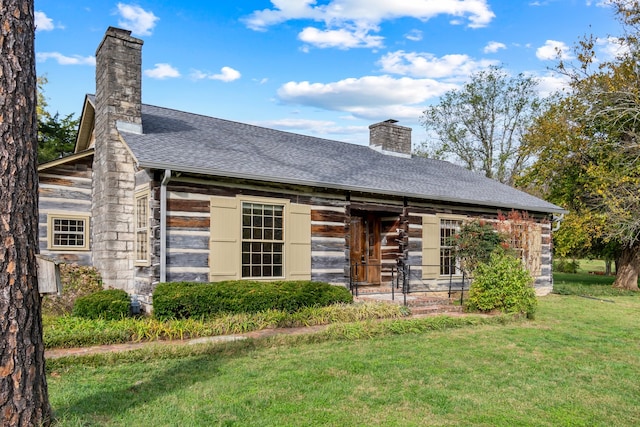 rear view of property with a yard