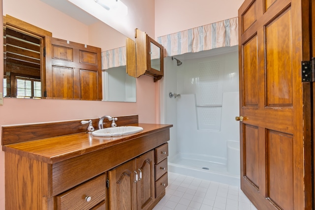 bathroom featuring tile patterned floors, a shower, and vanity