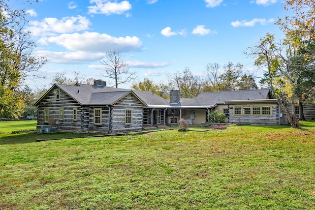 rear view of property with cooling unit and a lawn