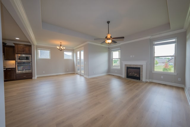 unfurnished living room with light wood-type flooring, ornamental molding, plenty of natural light, and a tile fireplace