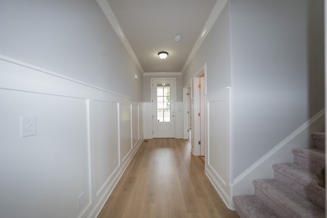 entryway with crown molding and light hardwood / wood-style floors