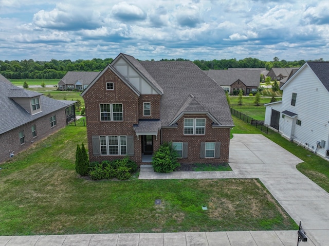 tudor home with a front yard and a garage