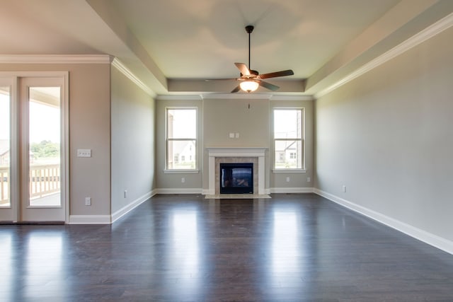 unfurnished living room with ornamental molding, dark hardwood / wood-style floors, a tile fireplace, and ceiling fan