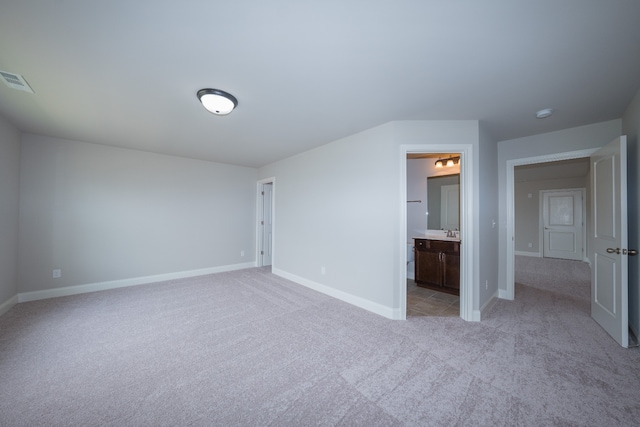 unfurnished bedroom with light carpet and ensuite bath