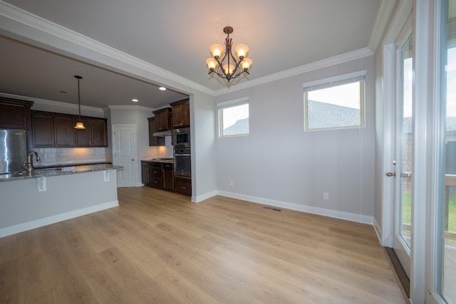 kitchen featuring decorative backsplash, dark brown cabinets, appliances with stainless steel finishes, light wood-type flooring, and light stone counters