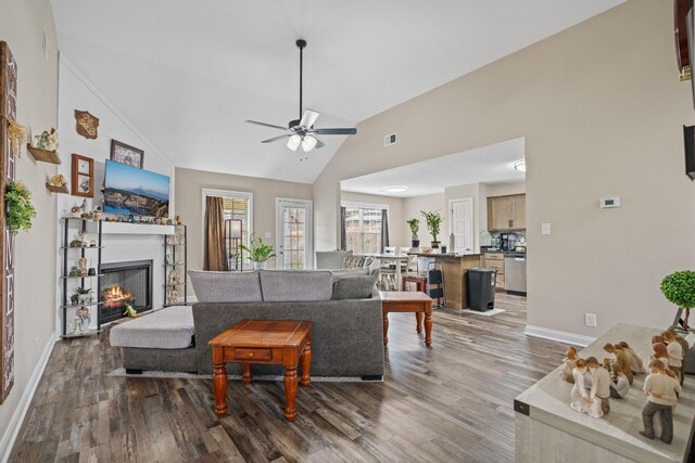 living room with hardwood / wood-style floors, high vaulted ceiling, and ceiling fan