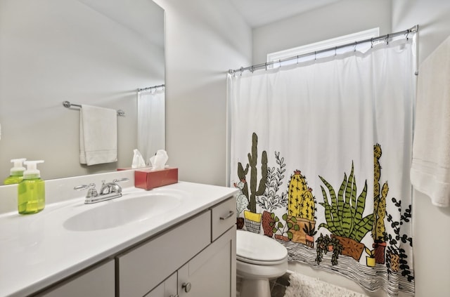 bathroom featuring vanity, curtained shower, and toilet