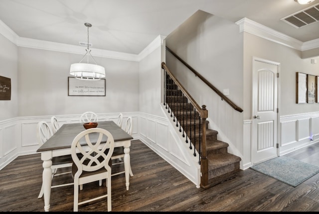 dining area featuring an inviting chandelier, crown molding, and dark wood-type flooring