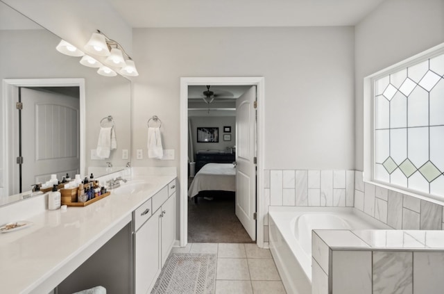 bathroom featuring vanity, a relaxing tiled tub, and tile patterned flooring