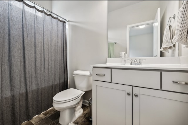 bathroom featuring vanity, curtained shower, and toilet