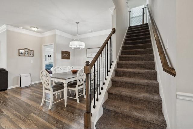 dining space featuring an inviting chandelier, ornamental molding, and dark wood-type flooring