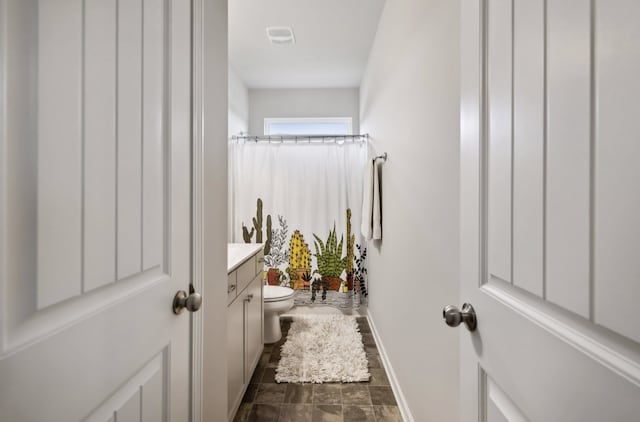 bathroom featuring toilet, curtained shower, and vanity