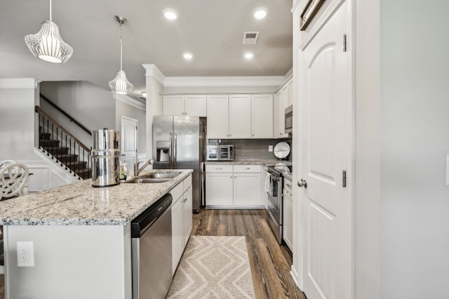 kitchen with an island with sink, hanging light fixtures, white cabinetry, stainless steel appliances, and dark hardwood / wood-style floors