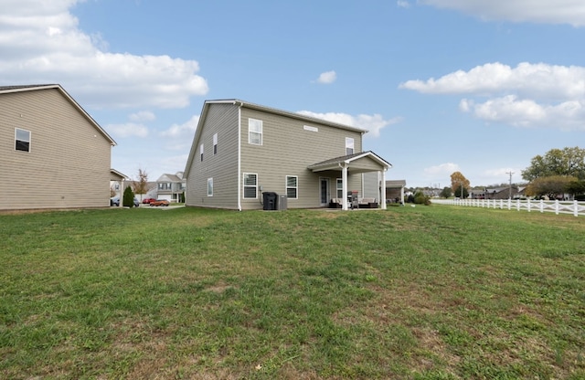 rear view of house featuring a patio and a lawn