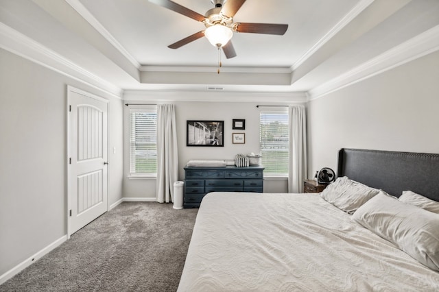 carpeted bedroom featuring ceiling fan, a raised ceiling, ornamental molding, and multiple windows