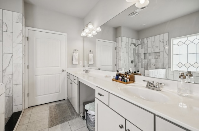 bathroom featuring vanity, tiled shower, and tile patterned flooring