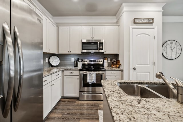 kitchen with dark wood-type flooring, stainless steel appliances, sink, light stone countertops, and white cabinets