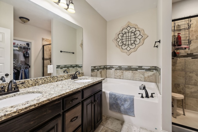 bathroom with vanity and shower with separate bathtub