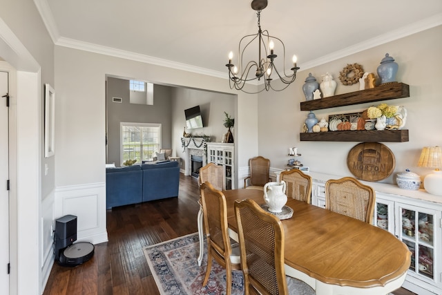 dining room with dark hardwood / wood-style flooring, an inviting chandelier, and ornamental molding