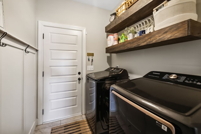 laundry room with independent washer and dryer and light tile patterned floors