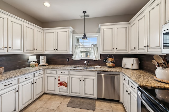 kitchen with decorative backsplash, stainless steel dishwasher, sink, decorative light fixtures, and white cabinets