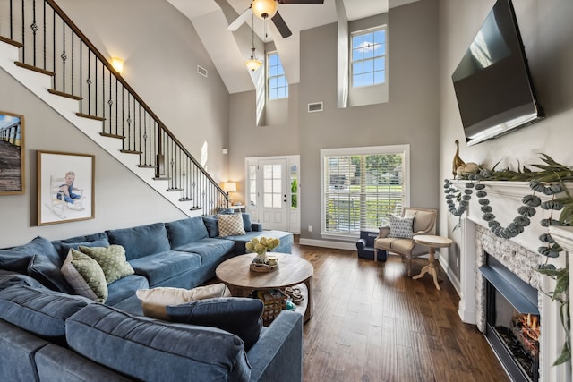 living room with dark hardwood / wood-style floors, a fireplace, and a high ceiling