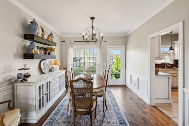 dining space with a chandelier, dark wood-type flooring, and ornamental molding