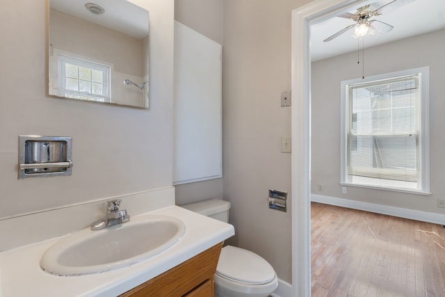 bathroom featuring toilet, hardwood / wood-style floors, vanity, and ceiling fan