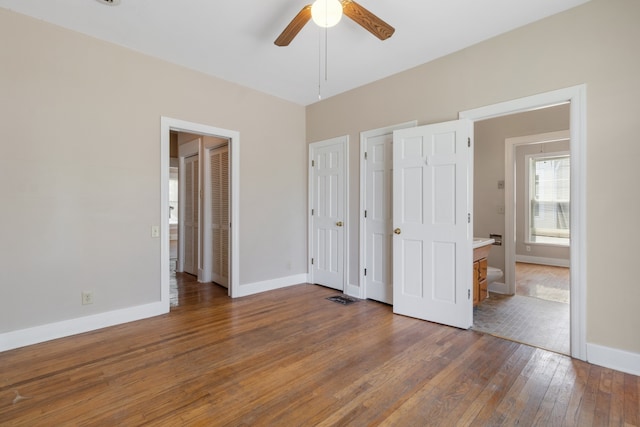 unfurnished bedroom featuring ceiling fan, dark hardwood / wood-style flooring, and ensuite bath