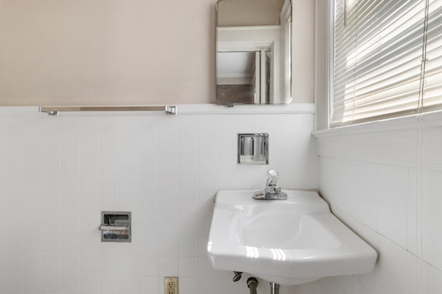 bathroom featuring tile walls and sink