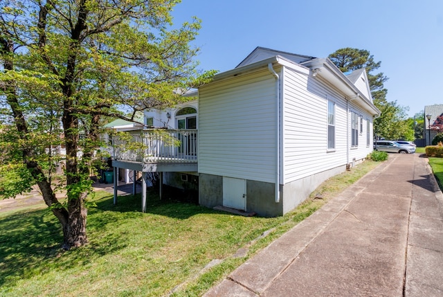 view of side of property with a deck and a lawn