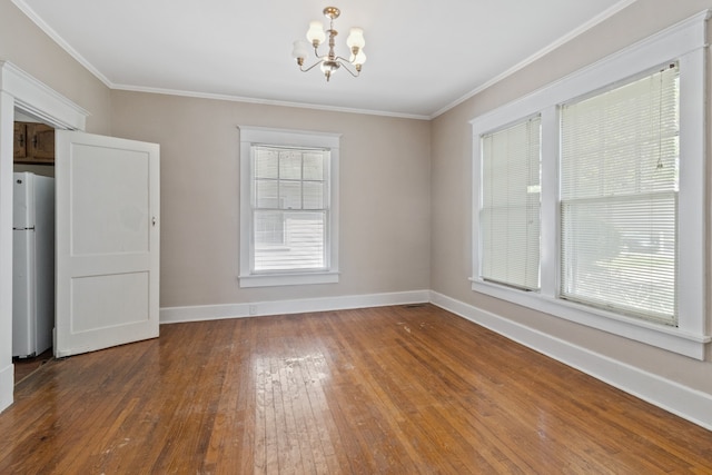 empty room featuring ornamental molding, a chandelier, and dark hardwood / wood-style floors